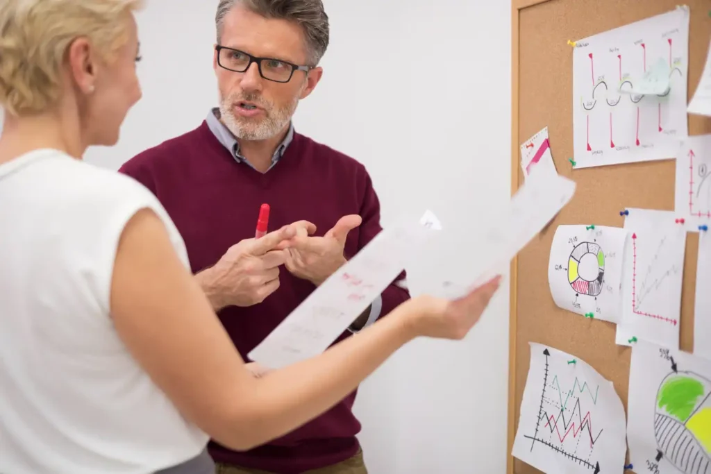 Profissionais discutindo estratégias de Business Intelligence na Gestão Empresarial, analisando gráficos e dados em um ambiente de trabalho colaborativo.